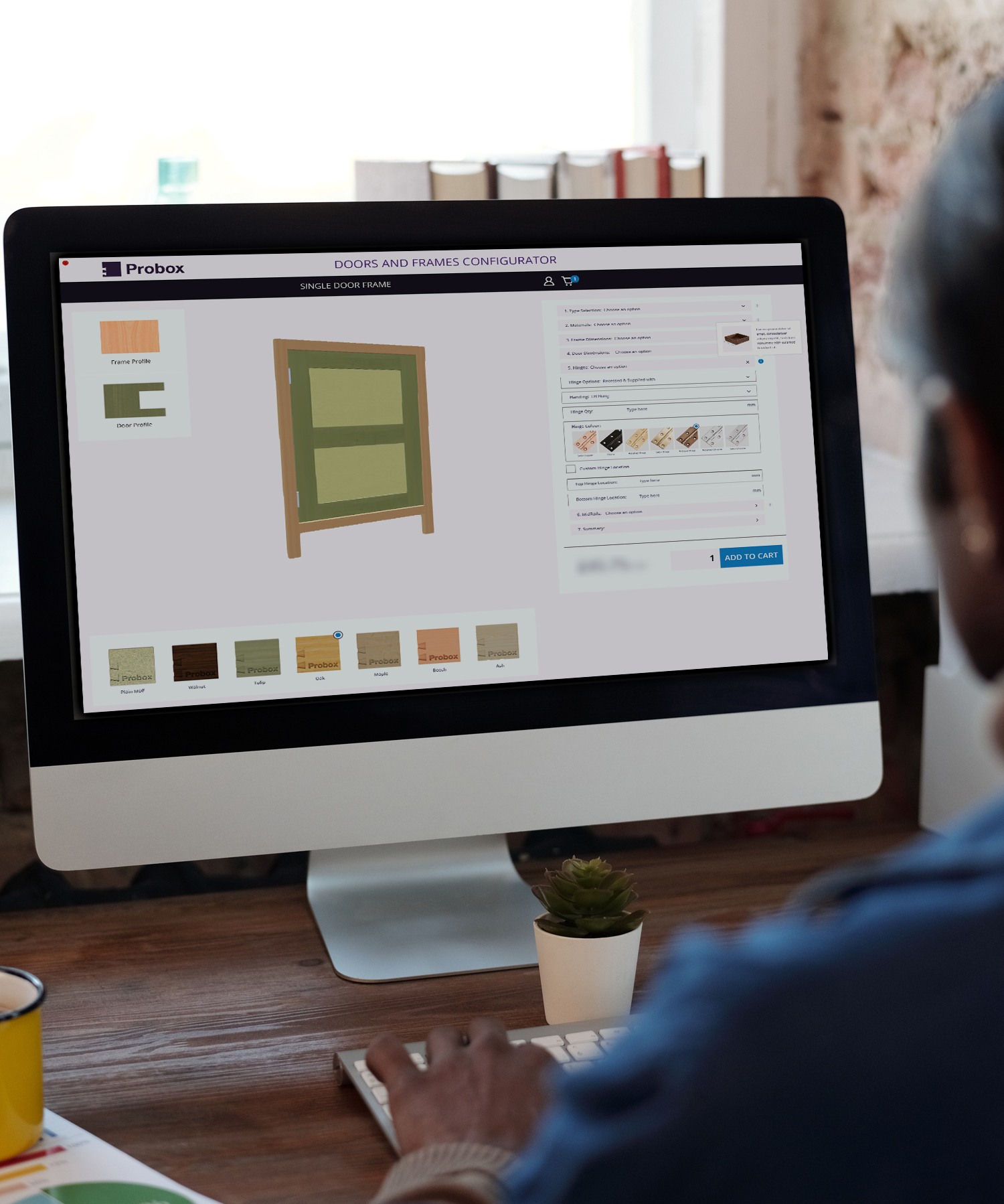 A man is using a computer to design a piece of Wooden furniture.