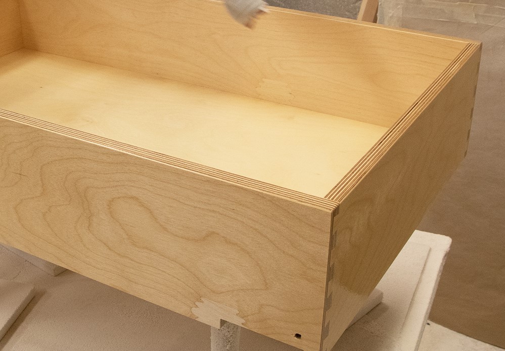 Plywood drawers having lacquer applied.